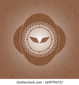 wings icon inside badge with wood background