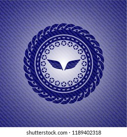 wings icon inside denim background