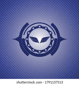 wings icon inside emblem with denim texture. 