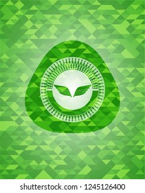wings icon inside green mosaic emblem
