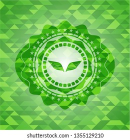 wings icon inside green mosaic emblem