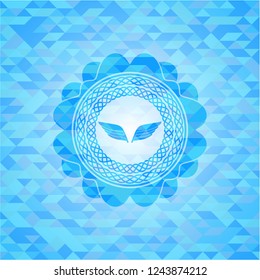 wings icon inside light blue emblem. Mosaic background
