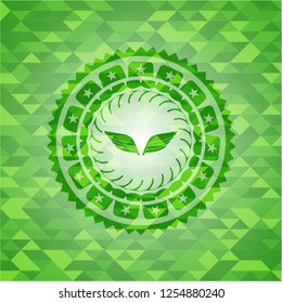 wings icon inside realistic green mosaic emblem