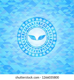 wings icon inside sky blue emblem. Mosaic background