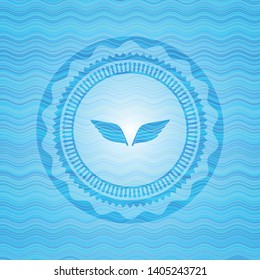wings icon inside sky blue water badge background.