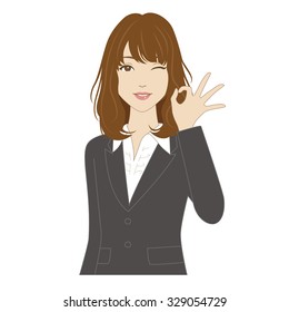 Winking young woman in business suit posing with okay sign