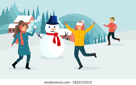 Winter activities concept. A young couple of a guy and a girl are making a snowman together and throwing snowballs enjoying the falling snow and winter nature on the background of a country landscape.