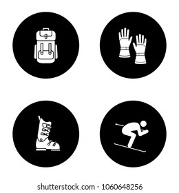 Winter activities glyph icons set. Backpack, skiing gloves and boots, skier. Vector white silhouettes illustrations in black circles