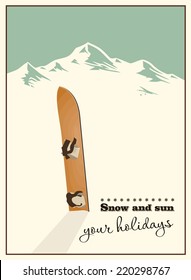 Winter  background. Mountains and old snowboard in the snow