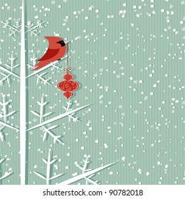 Winter background with red cardinal holding christmas decoration