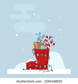Winter card with elegant red shoe with a presents, candy cane, branches and garland, on a blue background. vector illustration.