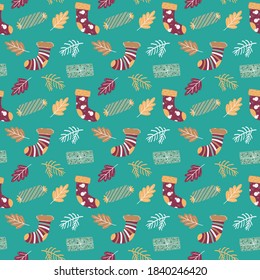 Winter Christmas vector seamless pattern with socks, presents, fir branches and leaves on blue background.