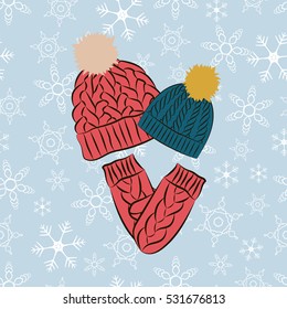 Winter clothes set. Knitted colored hats and mittens on the blue snowflakes background.