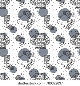 Winter clothes, vector seamless pattern with items like sweater with deer, mittens, sock, tangle of thread and knitting needles. Handmade style, doodle.
