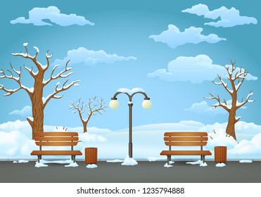 Winter day park. Two benches with trash cans and street lamp on an asphalt park trail with snow covered leafless trees and bushes.Snowy field and blue sky with clouds on a background.