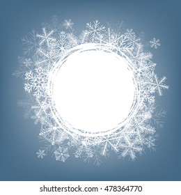 Winter frame made of fluffy snowflakes on soft blue background with space for text.