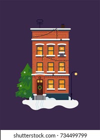 Winter holidays themed design element, vector. Flat design city red brick townhouse building in winter setting. Covered in snow residential building facade with lit up windows and christmas tree