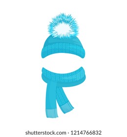 Winter knitted blue hat with a pompom and a scarf with fringe