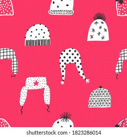 Winter pattern with knitted hats. Hand drawn seamless pattern. Red background.