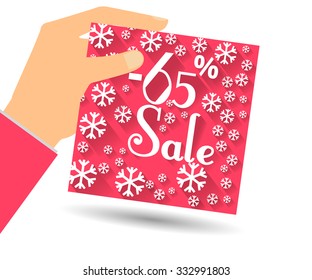 Winter sale. Discount 65 percent. Hand holds percent discount on the price. Gift card with a winter pattern with snowflakes in a flat style.