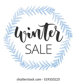 Winter sale hand written inscription with blue floral wreath on white background