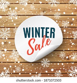 Winter sale round banner. Price tag on wooden background with snow and snowflakes. Promotion badge. Vector illustration.