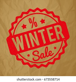 Winter Sale rubber stamp red on a crumpled paper brown background.