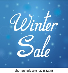 Winter sale. Vector inscription. Blue background. Image with blur effect.