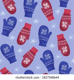 Winter seamless pattern of cozy knitted mittens of blue and red color with ornament. Warm clothes to protect hands from cold in winter. Against the background of white snowflakes. Christmas mood