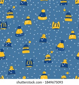 Winter seamless pattern with winter hats on blue background. Cute vector winter warm knitted clothes in cartoon style. Christmas vector illustration. Holiday New Year design.