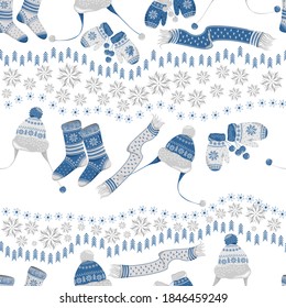 Winter seamless pattern with warm clothing elements and snowflakes isolated on white background. Vector. Mittens, socks, scarves, hats with blue and white ornaments