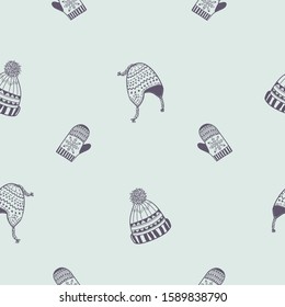 Winter seamless pattern. Warm knitted hats and mittens vector background design.