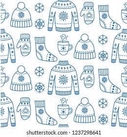 Winter season clothes seamless pattern with sweater, mitten, hat, socks with ornament. Blue outline background with knitted hipster accessories. Hand drawn vector sketch elements.