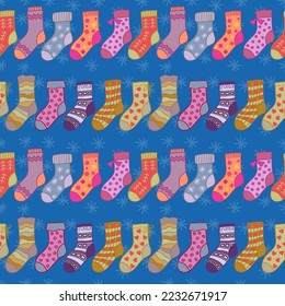 Winter socks seamless pattern on blue background. Different texture and color cartoon socks in a row. For textile, wrapping paper, packaging.