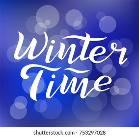 Winter time custom white lettering text on blurred background with lights, vector illustration. Winter time calligraphy for logo, invitation, poster, decoration and postcards. Winter  vector design.