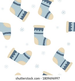 Winter vector seamless pattern with knitted  socks and snowflakes. Warm clothing for feet. For design of packaging paper, textiles, templates or fabric.