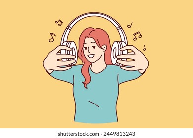 Auriculares inalámbricos en manos de mujer invitándote a escuchar canciones populares o transmisiones de radio juntos. Chica alegre con auriculares, orgullosa de la lista de reproducción recogida de composiciones raras