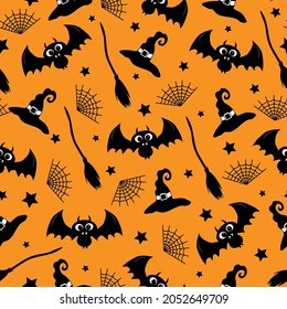 Witch hat, bat, spider web, and broom hand drawn seamless pattern on orange color background for Halloween.