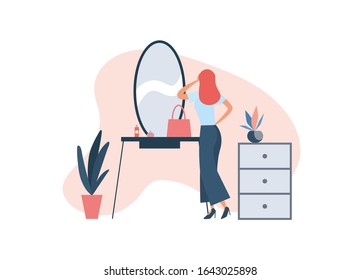 Woman applying makeup at home. Elegant lady standing near console mirror with cosmetic and bag and applying makeup while getting ready for work during beauty routine at home