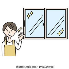 A woman in an apron with a clean window and an OK sign