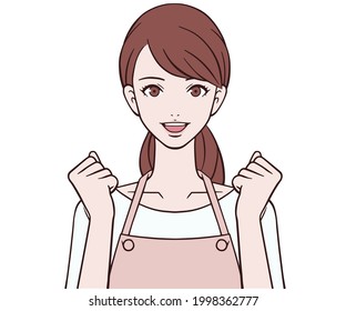 A woman in an apron doing a guts pose with a smile