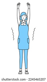 A woman in an apron stretching and standing tall.