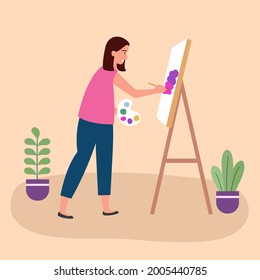 Woman artist painting on easel. Woman painting picture as her hobby. Creative activity at home.