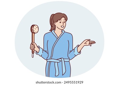 Woman in bathrobe holding shower brush in hand going to take bath and do self bodycare or anti-aging treatments. Positive girl after shower points to side, drawing your attention to importance hygiene