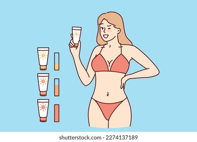 Woman in beach tanning bikini demonstrates anti-sunburn cream. Girl recommends purchasing high-quality tanning cream that promotes appearance of uniform skin tone when visiting solarium 