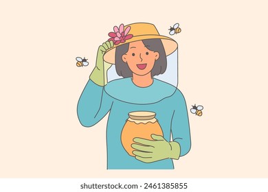Woman beekeeper holds jar of honey, standing among flying bees, uses net and gloves to protect skin. Happy girl beekeeper is engaged in farming and producing organic food or propolis.