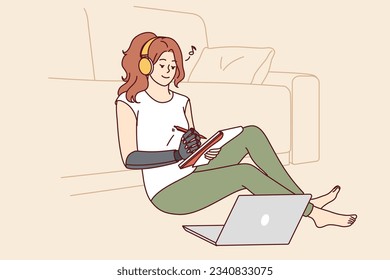 Woman with bionic prosthetic arm sits on floor near sofa and makes notes in notebook. Girl with prosthesis listens to music in headphones and smiles, for concept of love of life or vitality