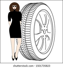 Woman in a black dress standing near a huge wheel