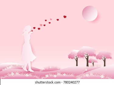 Woman blowing heart in hand on pink background, paper art, paper craft style illustration