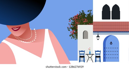 Woman with blue hat and pearls necklace, on background of typical morocco style mediterranean village. Blue door under a roof, Moorish windows, chairs and a small table with vase. Bougainvillea